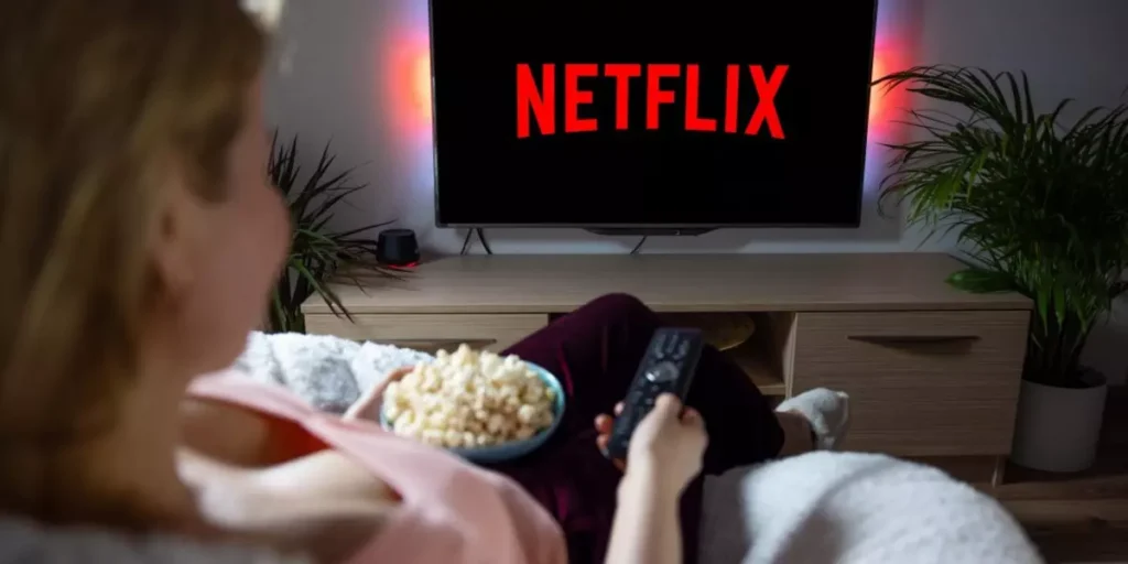 Pessoa assistindo à Netflix na televisão em casa, representando como o planejamento estratégico permitiu à empresa crescer e negociar com grandes estúdios do mercado audiovisual.